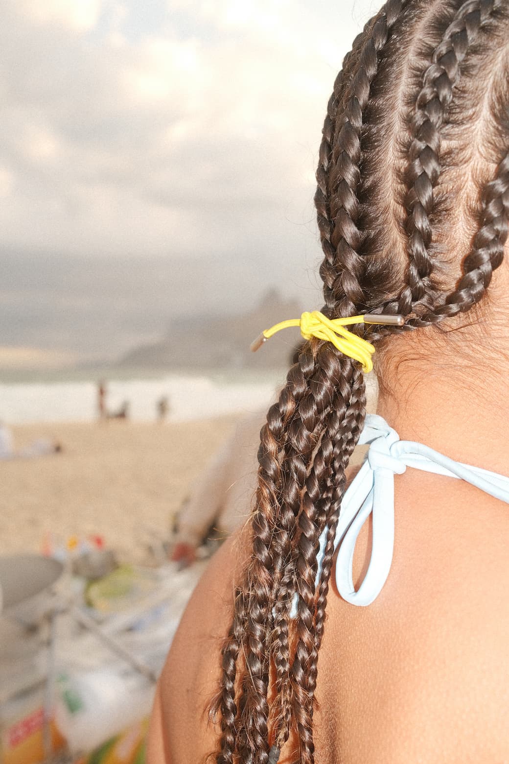 Loopi yellow hair tie in braids at the beach